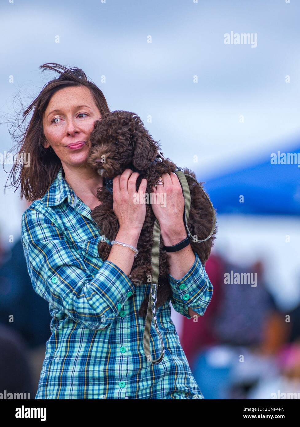 A portrait of a woman carrying her small dog sat on her shoulder Stock