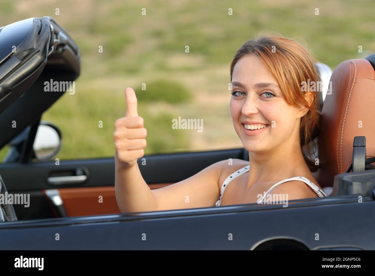 Happy car driver looking at camera gesturing thumbs up Stock Photo