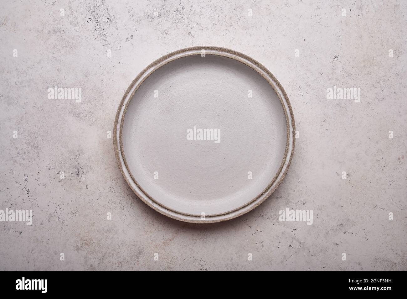 Empty ceramic plate on light concrete table background. Copy space. Menu recipe concept. Top view. Flat lay Stock Photo