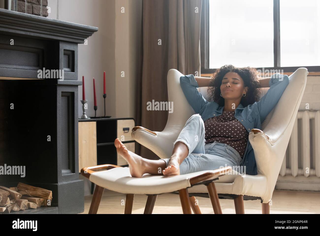 Relaxed African American woman sitting resting in comfortable armchair Stock Photo