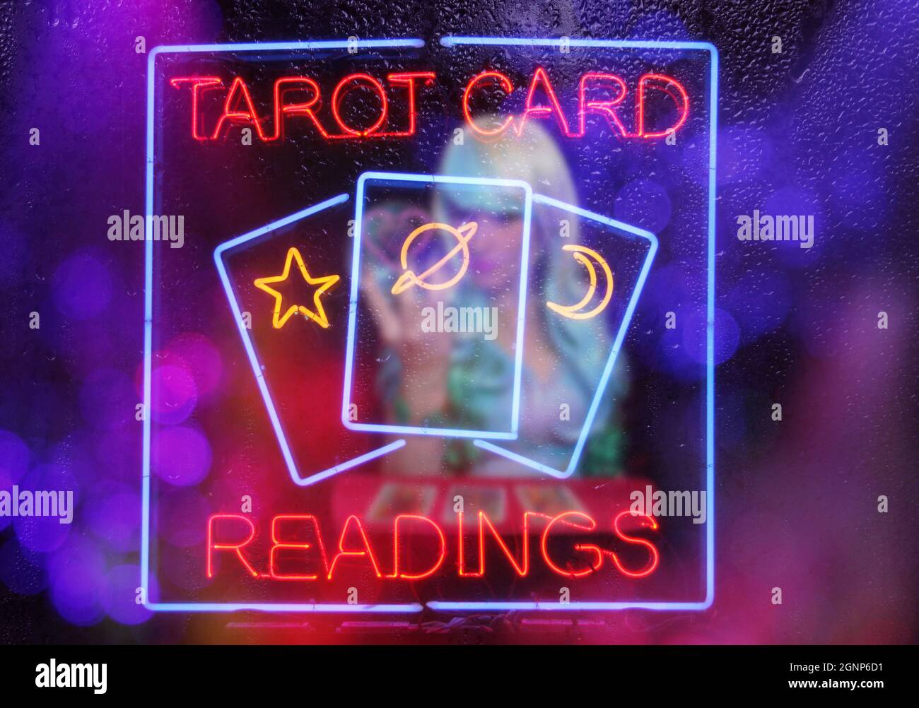 Tarot Card Readings Neon Sign in Window with Psychic Tarot Card Reader blurred in background Stock Photo