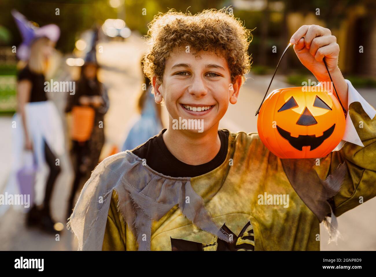 White boy smiling while trick-or-treating with her friends during ...