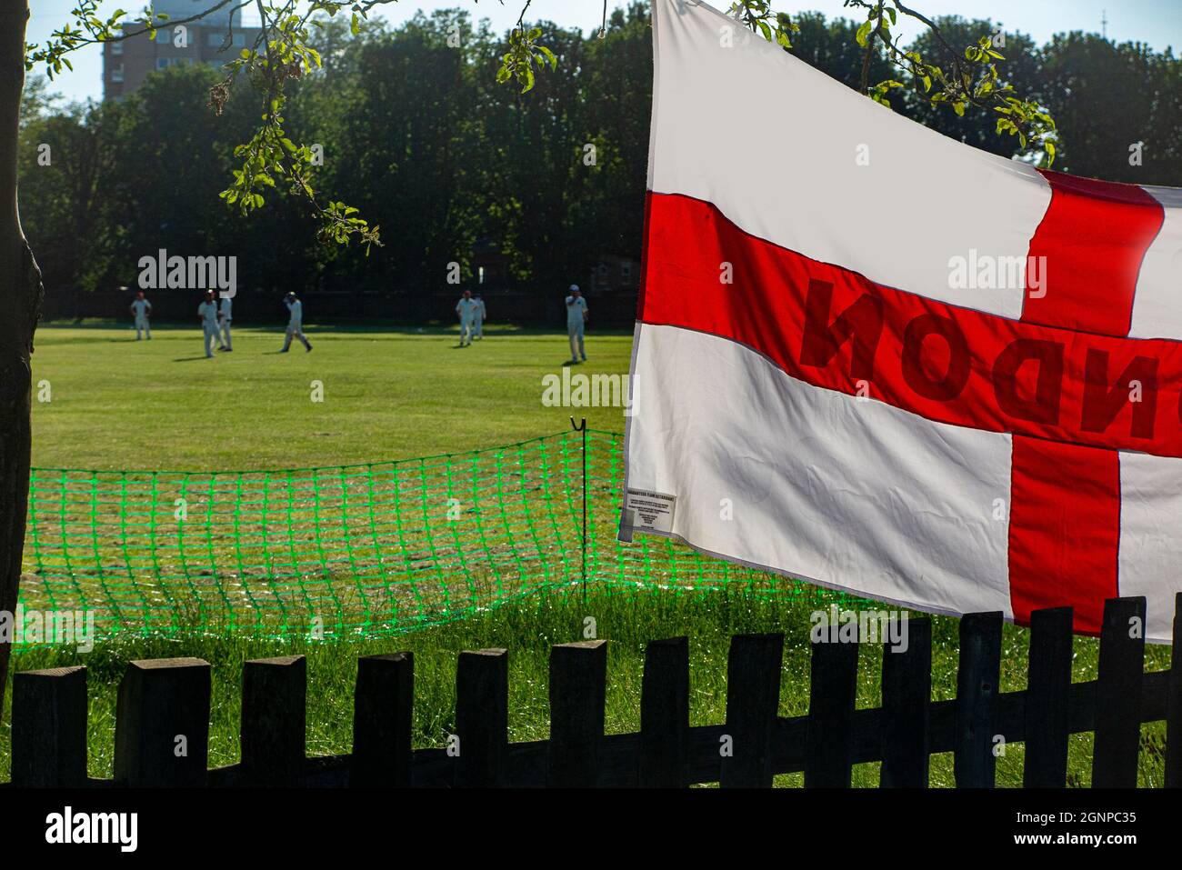 Grass roots cricket in a London park with a St George's flag Stock Photo
