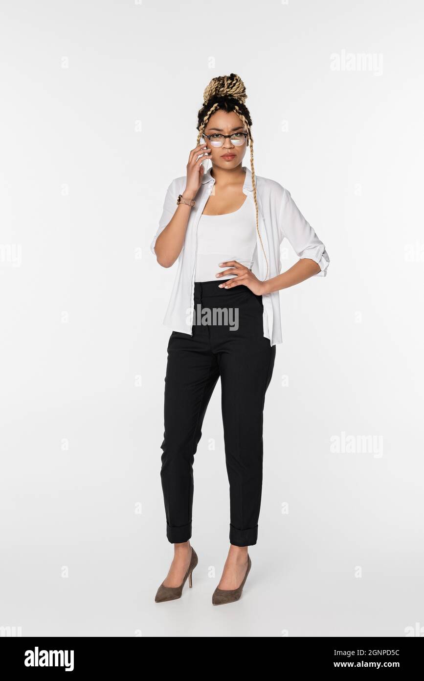 serious african american businesswoman standing with hand on hip and ...