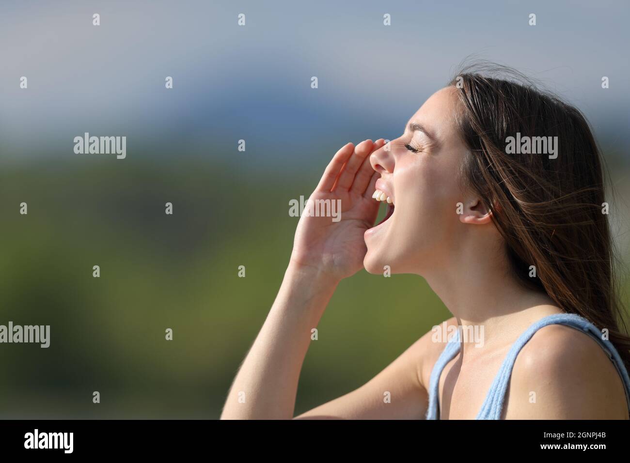 Profile of a woman shouting loudly in nature Stock Photo