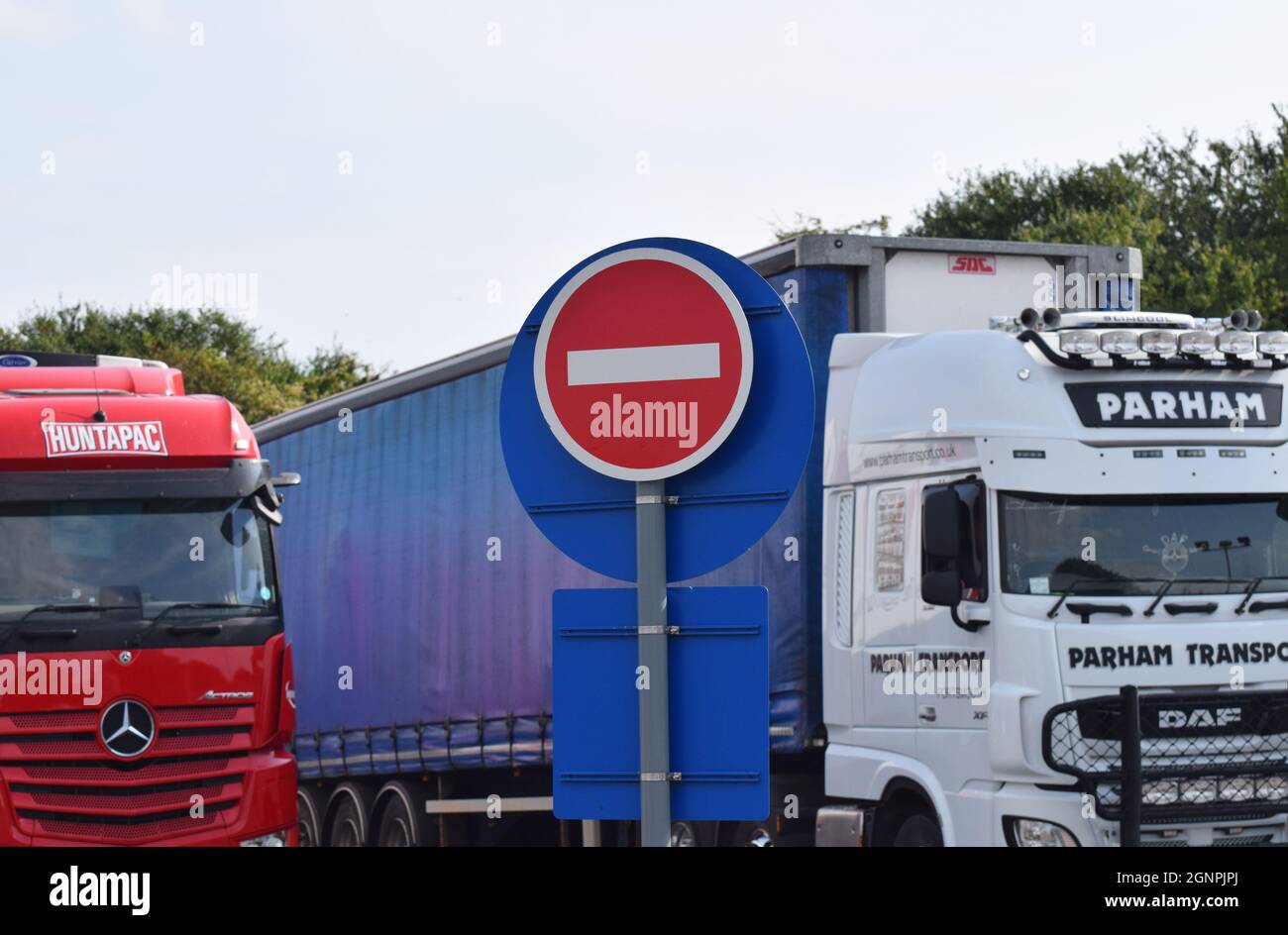 Parked Heavy Goods Vehicles HGVs in a service station behind a No Entry sign A metaphor for barriers to foreign workers filling driver jobs in the UK Stock Photo
