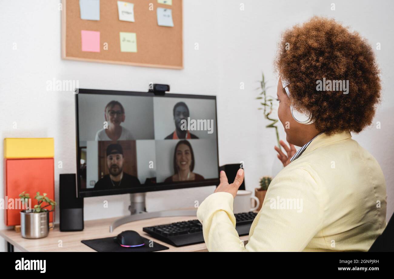 African woman doing video call meeting with co-workers from home - Lifestyle and technology concept - Focus on head Stock Photo