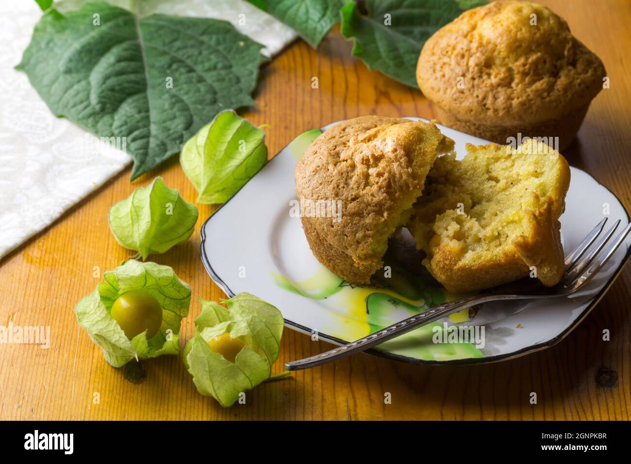 Gooseberry muffin on plate with gooseberries in foreground Stock Photo