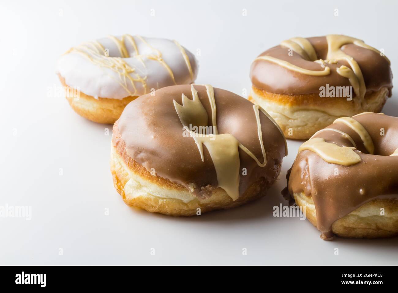Glazed donuts with chocolate, vanilla and caramel frosting - rustic style delicious doughnut background with copy space Stock Photo