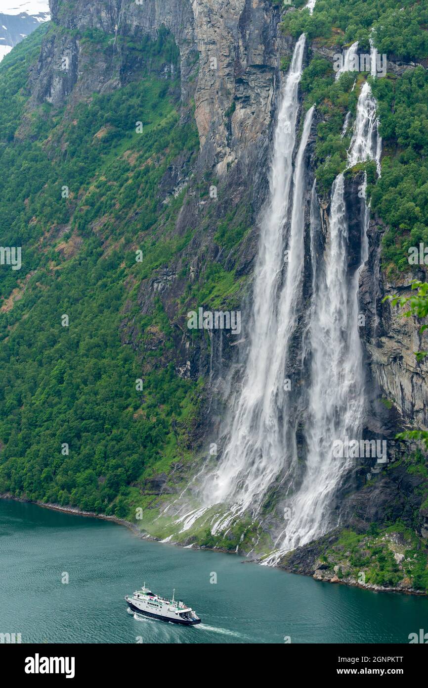 GEIRANGER, NORWAY - 2020 JUNE 21. Ferry passing the famous Seven Sisters waterfall in the Geiranger Fjord Stock Photo