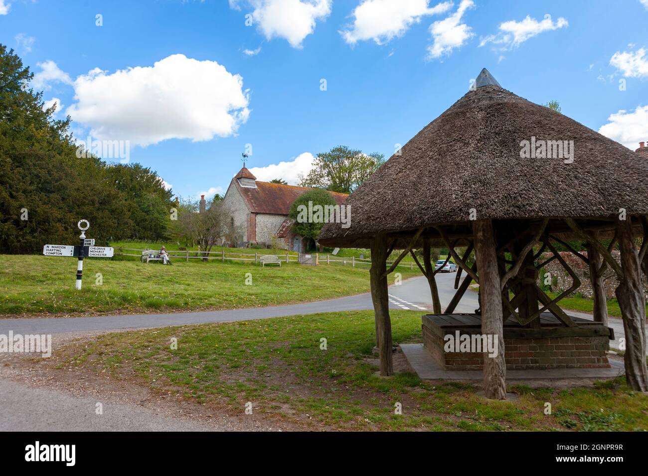 Thatched well on the village green and St. Peter's church beyond, East