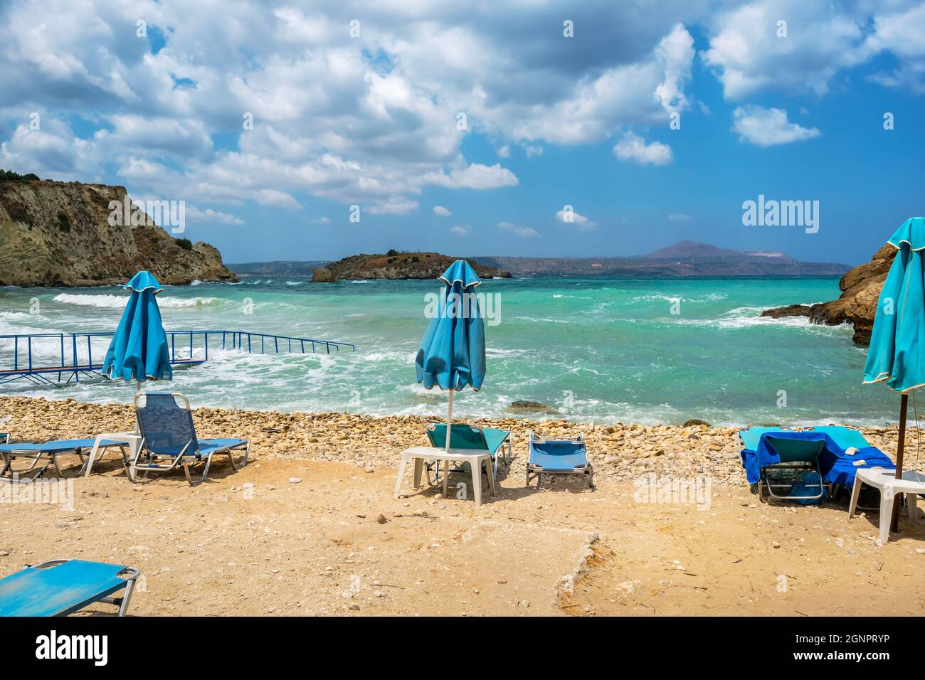 Sun loungers and close parasols on empty beach at stormy day. Almyrida. Crete, Greece Stock Photo