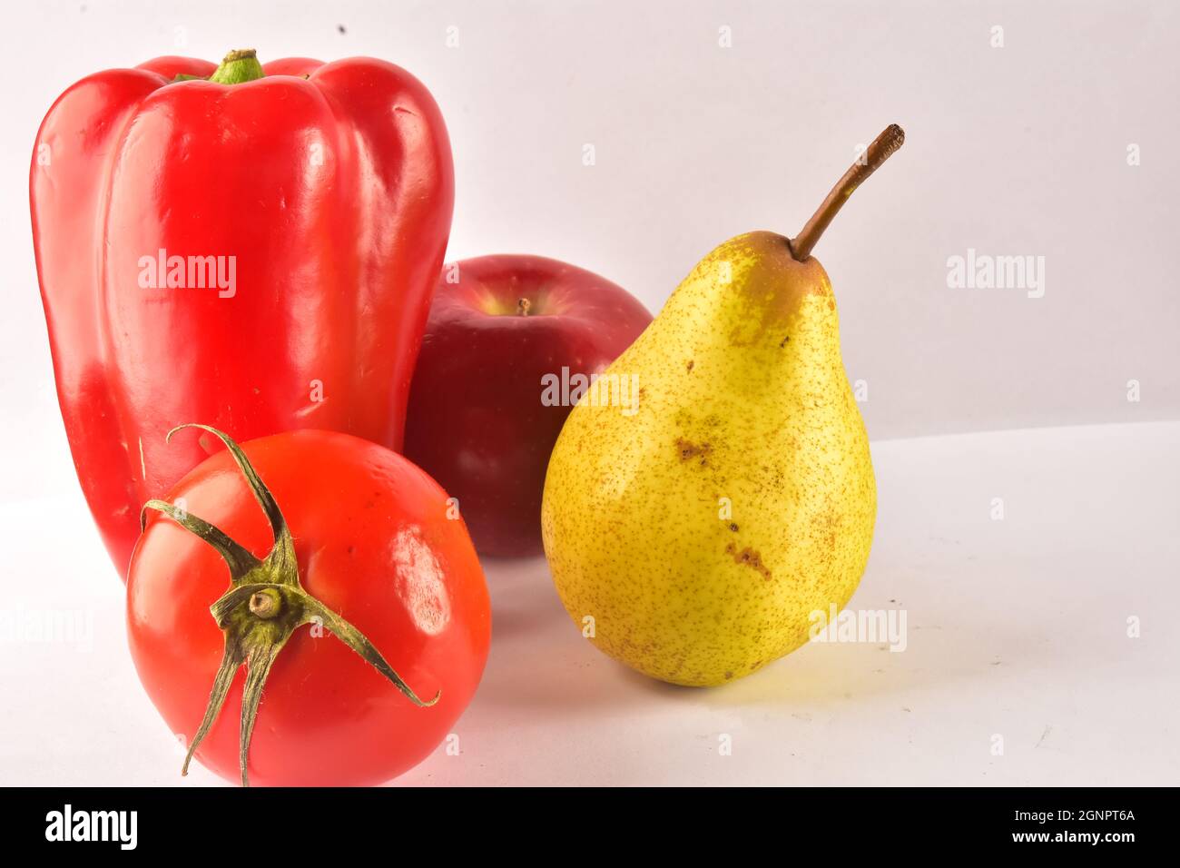 Red pepper, pear, tomato and apple on the table Stock Photo