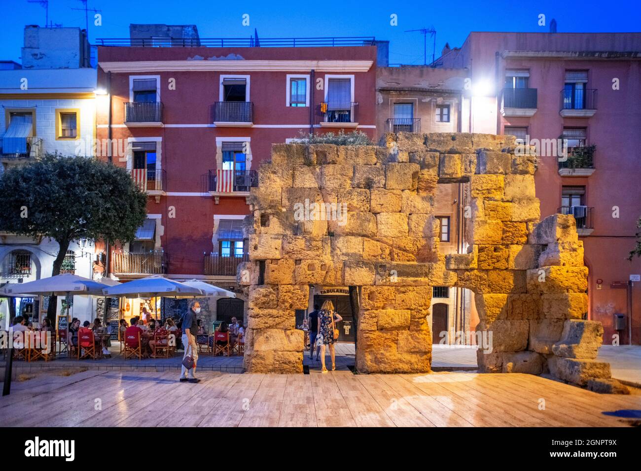 Roman ruins facades of houses buildings and restaurants in Plaça del