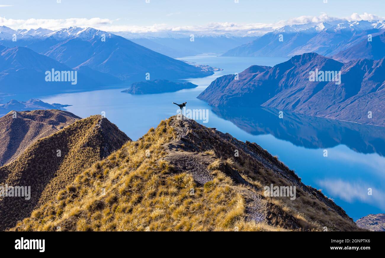 Asian tourist practicing martial arts side leg kick at Roy's Peak Lake Wanaka New Zealand Stock