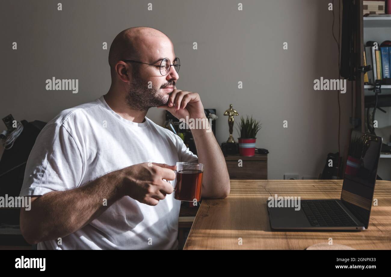Young man taking a tea break while working at home. young man working from his home. Stock Photo