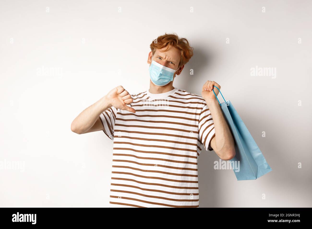 Concept of social distancing and shopping. Disappointed young man with ...