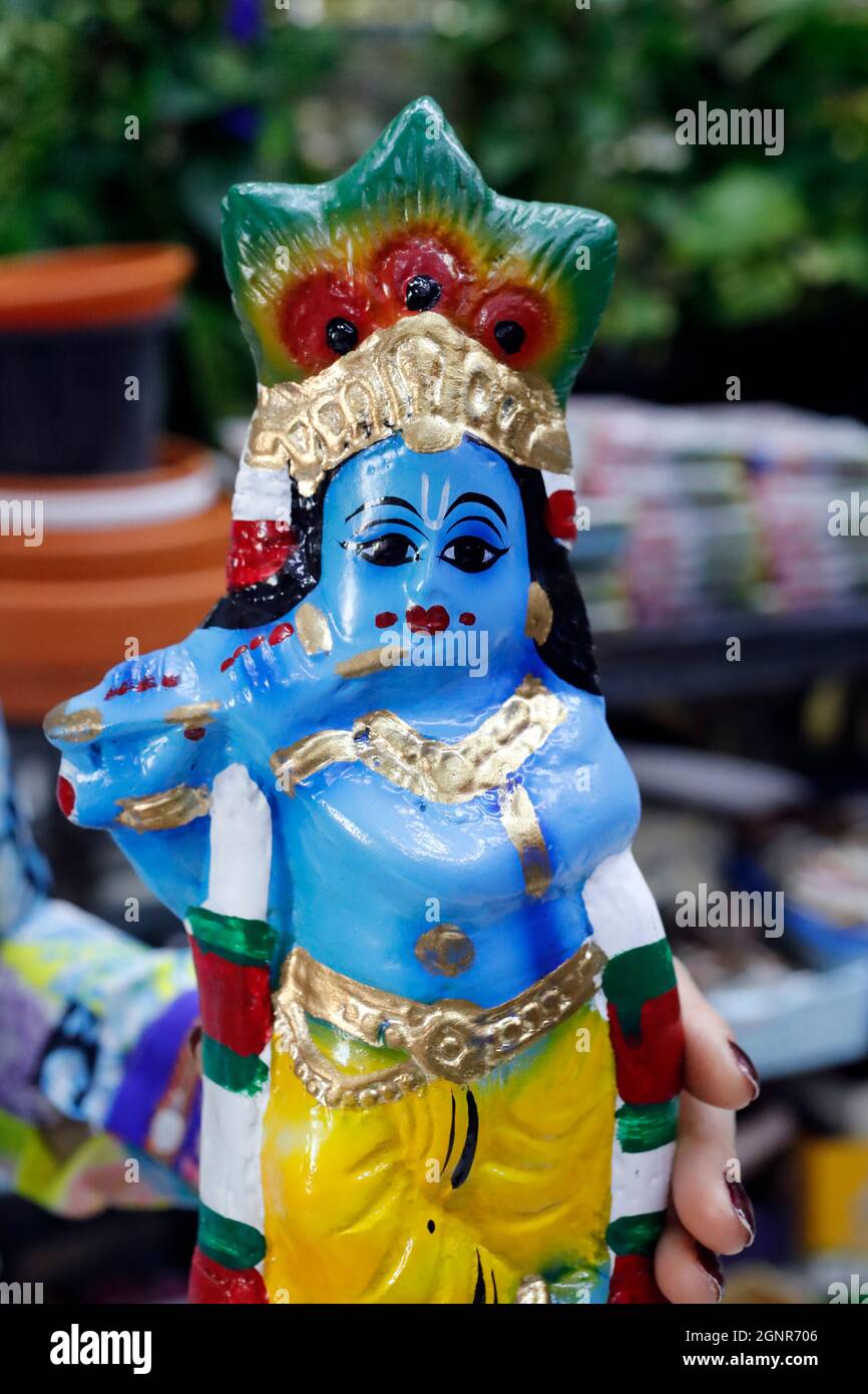 Religious hindu god statues for sale in spiritual shop. Figurine of Lord Krishna with flute