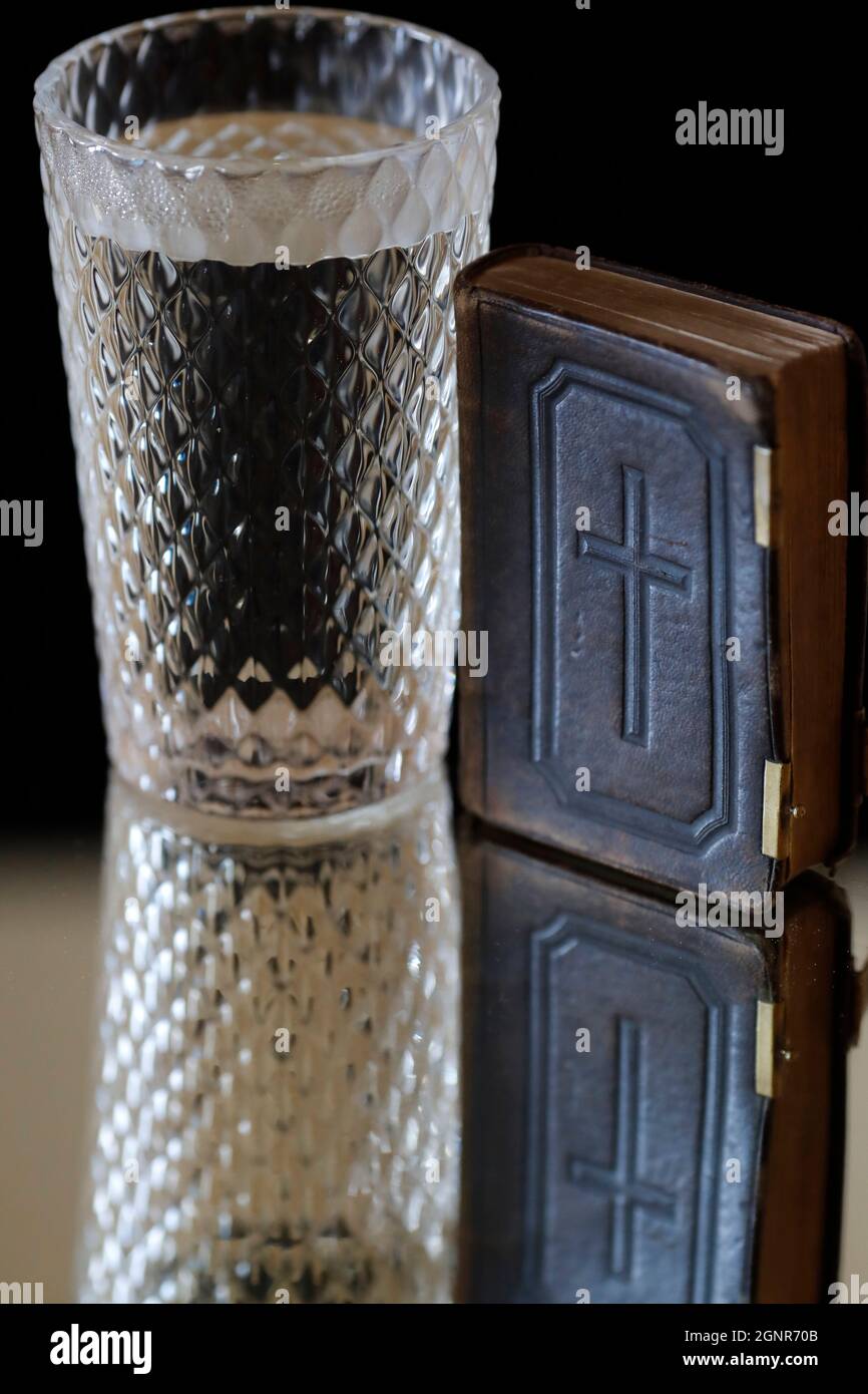 Glass of water, and old Bible during Lent. A solemn religious