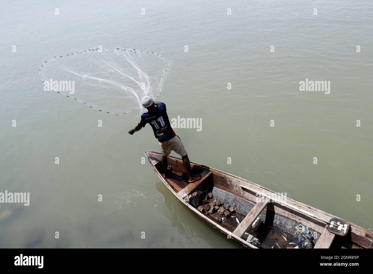 African fisherman throwing net into the river in traditional way.  Benin. Stock Photo