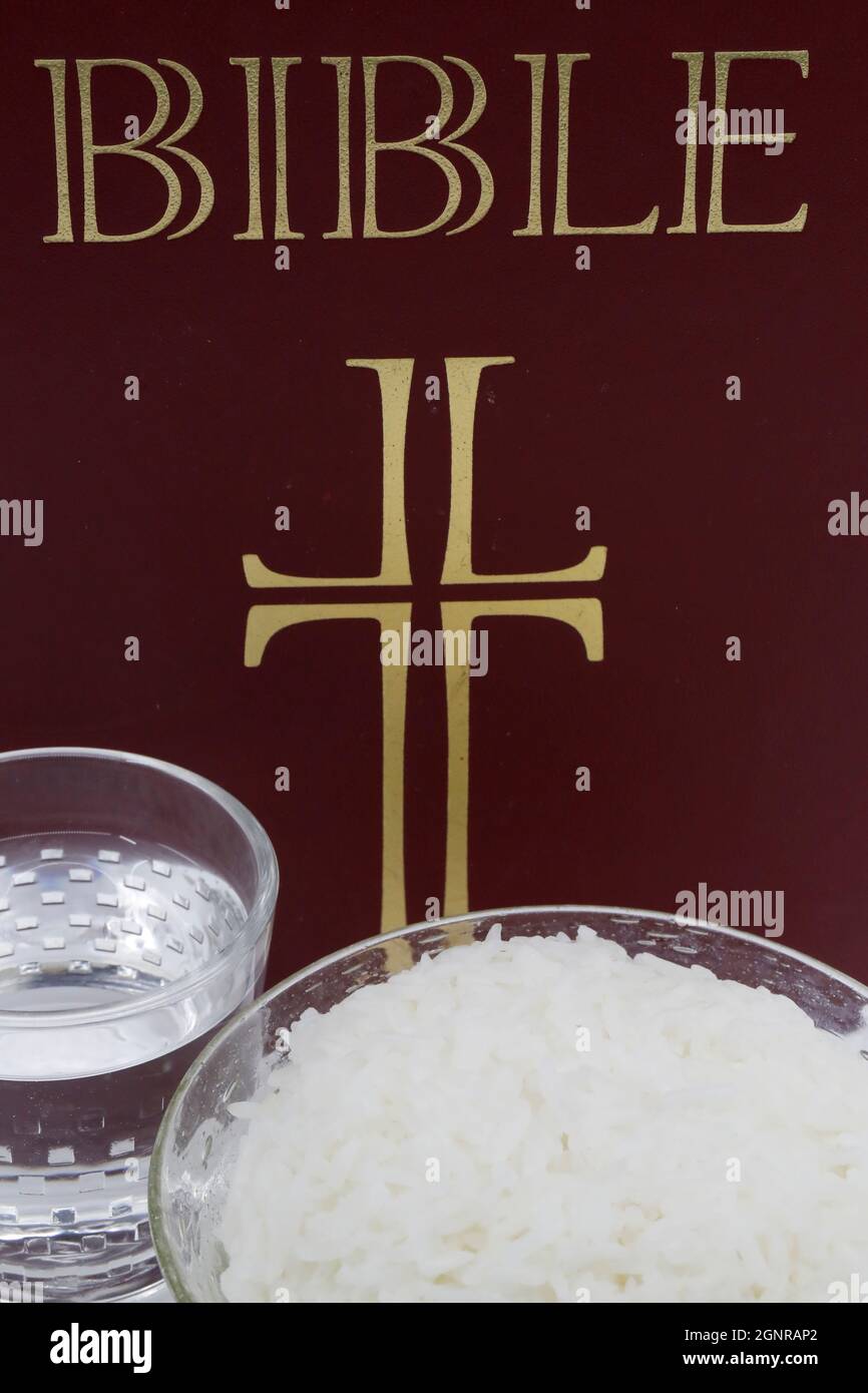 Bowl of rice, glass of water, and Bible during Lent. A solemn religious