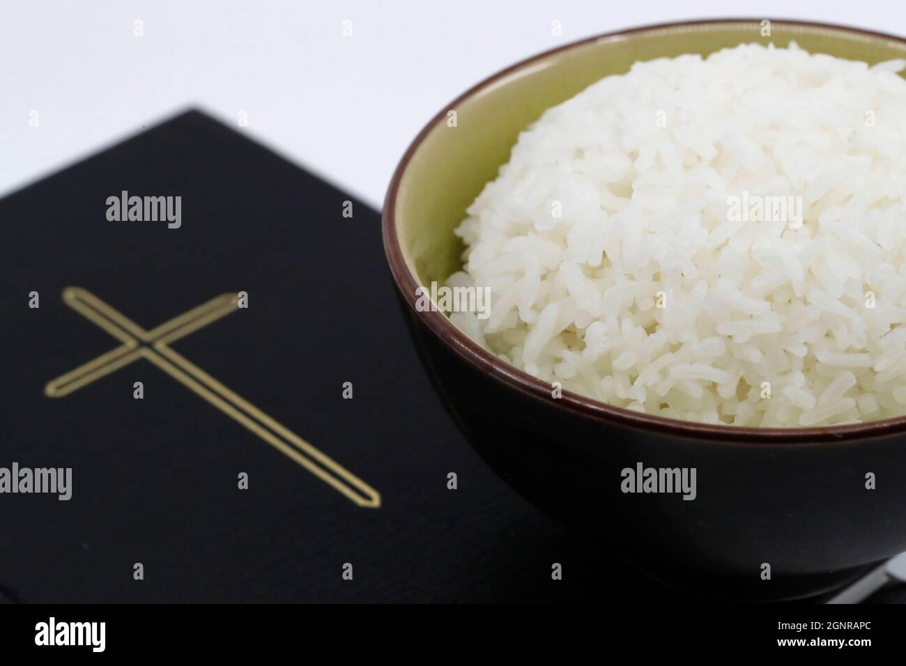 Bowl of rice and Bible during Lent. A solemn religious observance that begins on Ash Wednesday