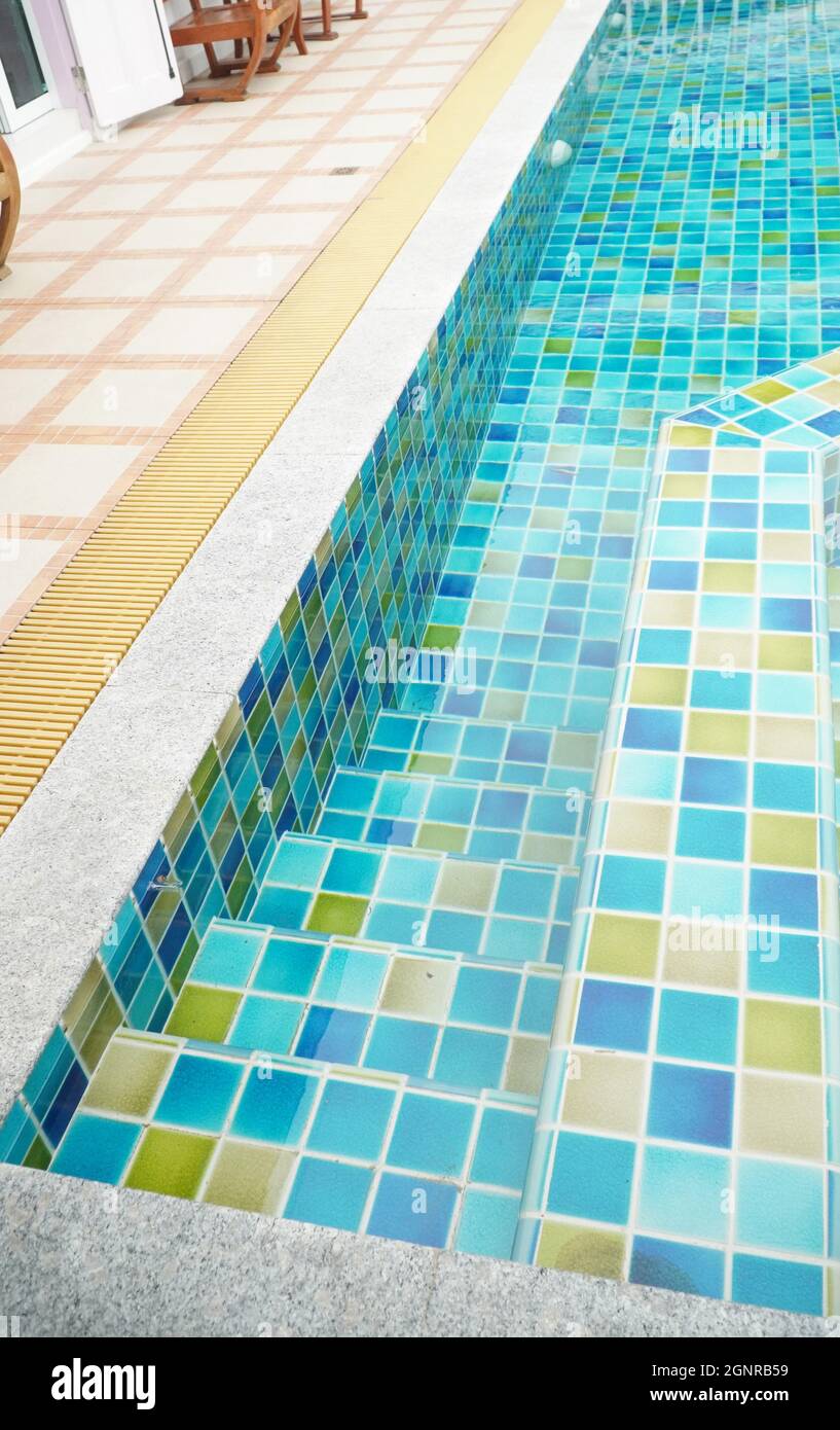 Stair way to step down into swimming pool with clear and clean water