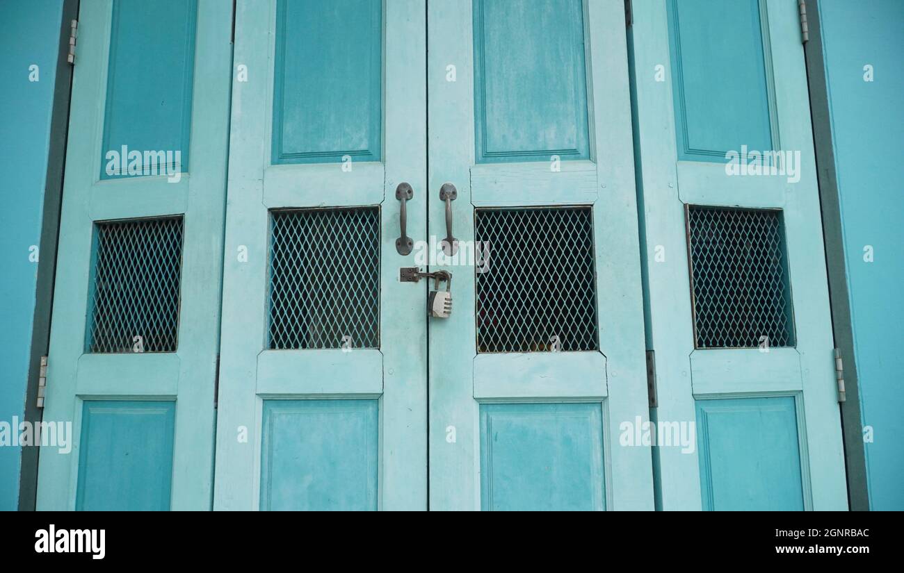 Blue vintage folding door with retro padlock and metal rusted handle Stock Photo