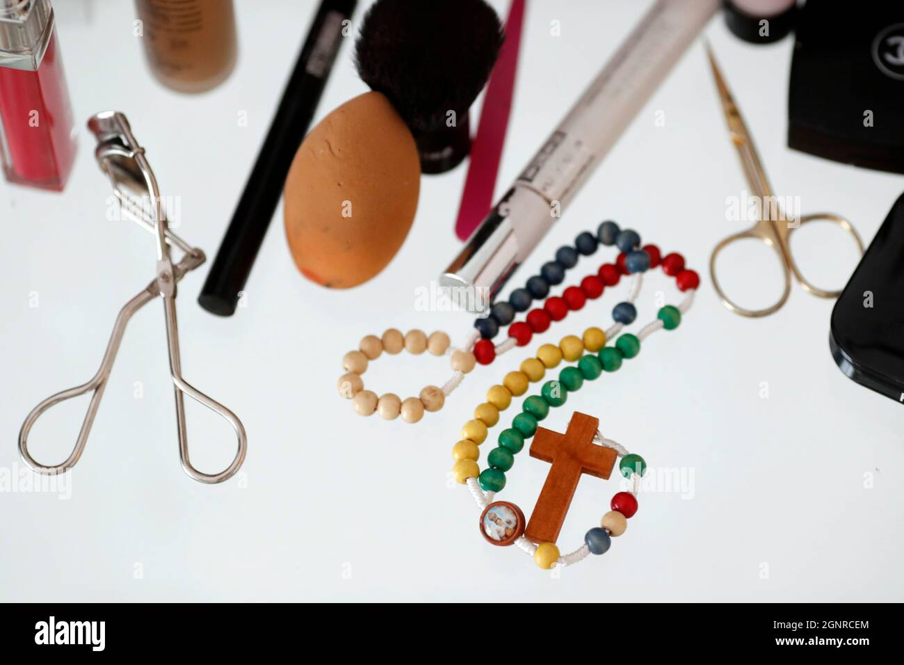 Makeup products and prayer beads on table. Stock Photo