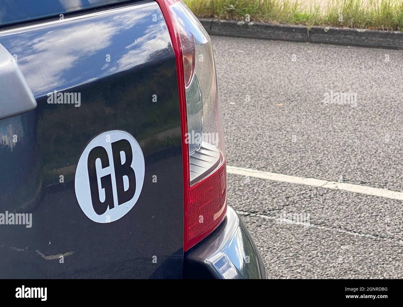 27 September 2021, United Kingdom, London: A "GB" sticker is stuck on a car. The country is called the United Kingdom, but the international identification mark has been "GB" for decades. In future, cars travelling abroad will have to carry a sticker with the words "UK" on the back. The current "GB" will then no longer be valid on its own as of September 28. (To dpa: "Symbol for union after Brexit: "UK" instead of "GB" on British cars") Photo: Benedikt von Imhoff/dpa Stock Photo