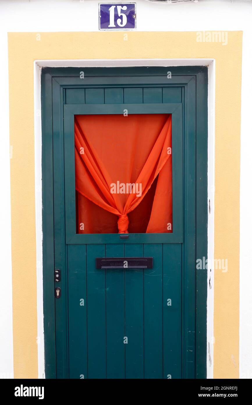Green door and red curtain in old town.  Evora. Portugal. Stock Photo