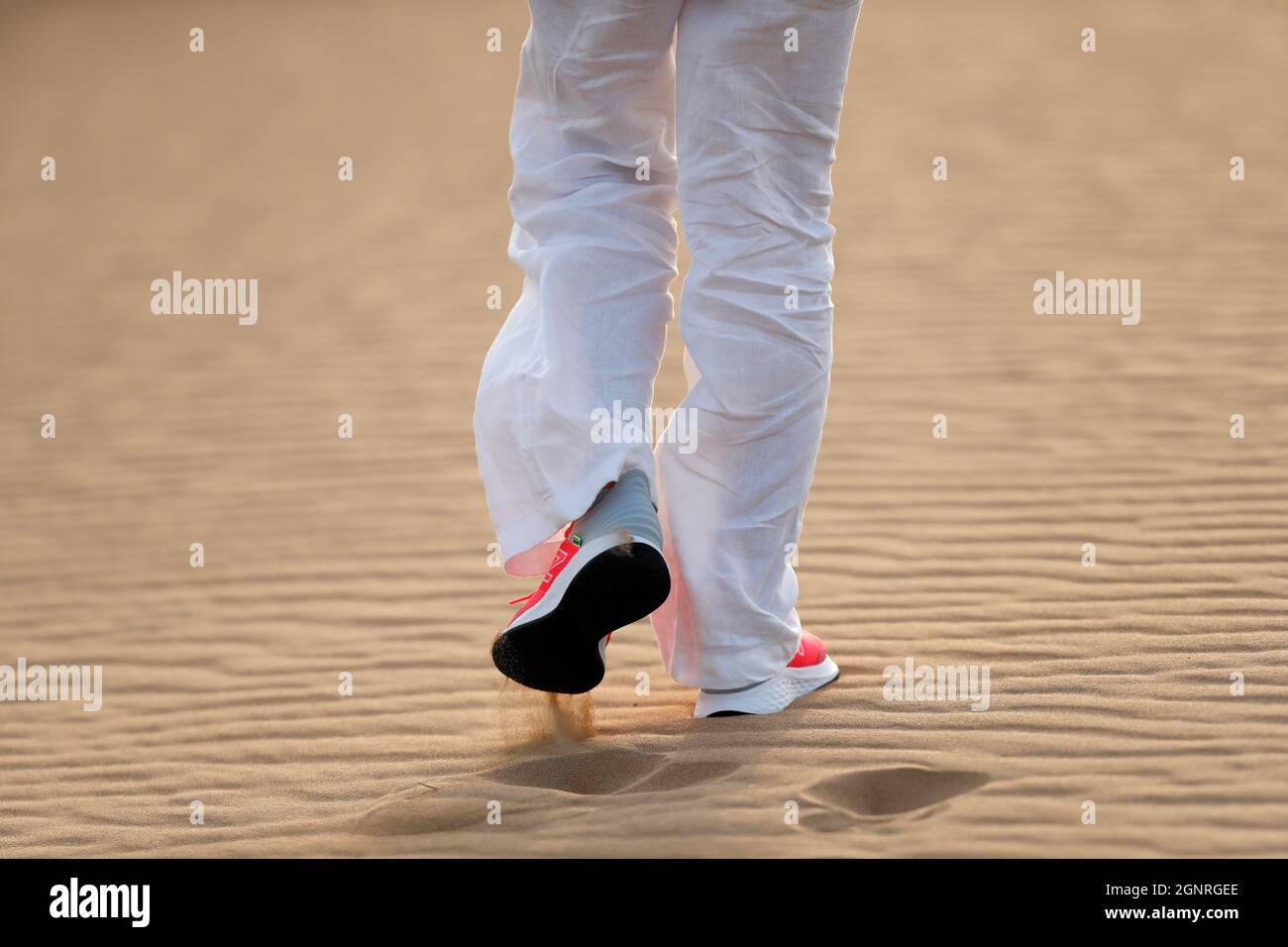Woman hiking in desert sand dunes. Closeup on shoes. Dubai. United