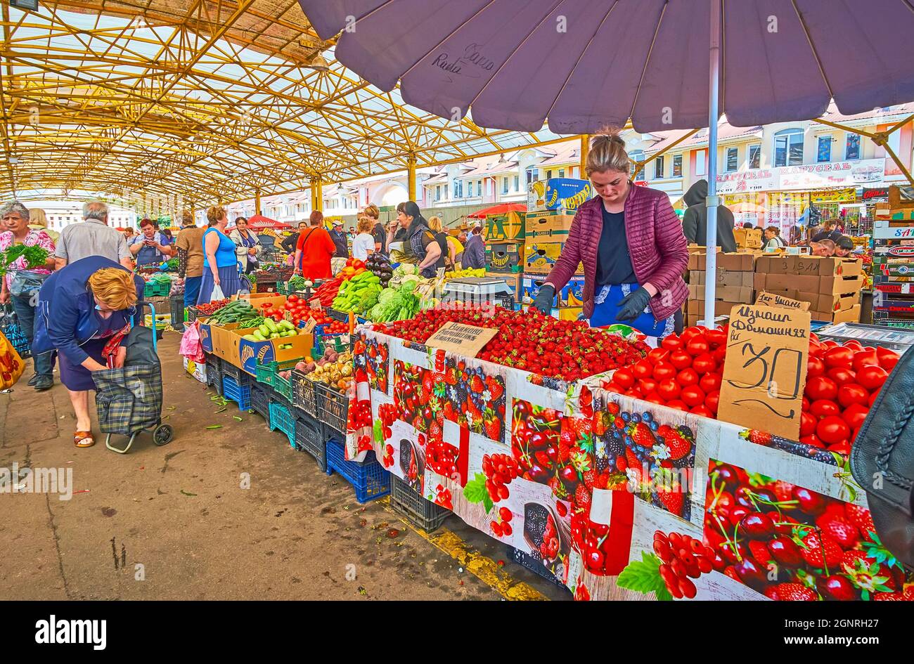 ODESSA, UKRAINE - June 18, 2021: The heaps of bright red tomatos and fragrant strawberry of local farmers in Pryvoz Market, on June 18 in Odessa Stock Photo