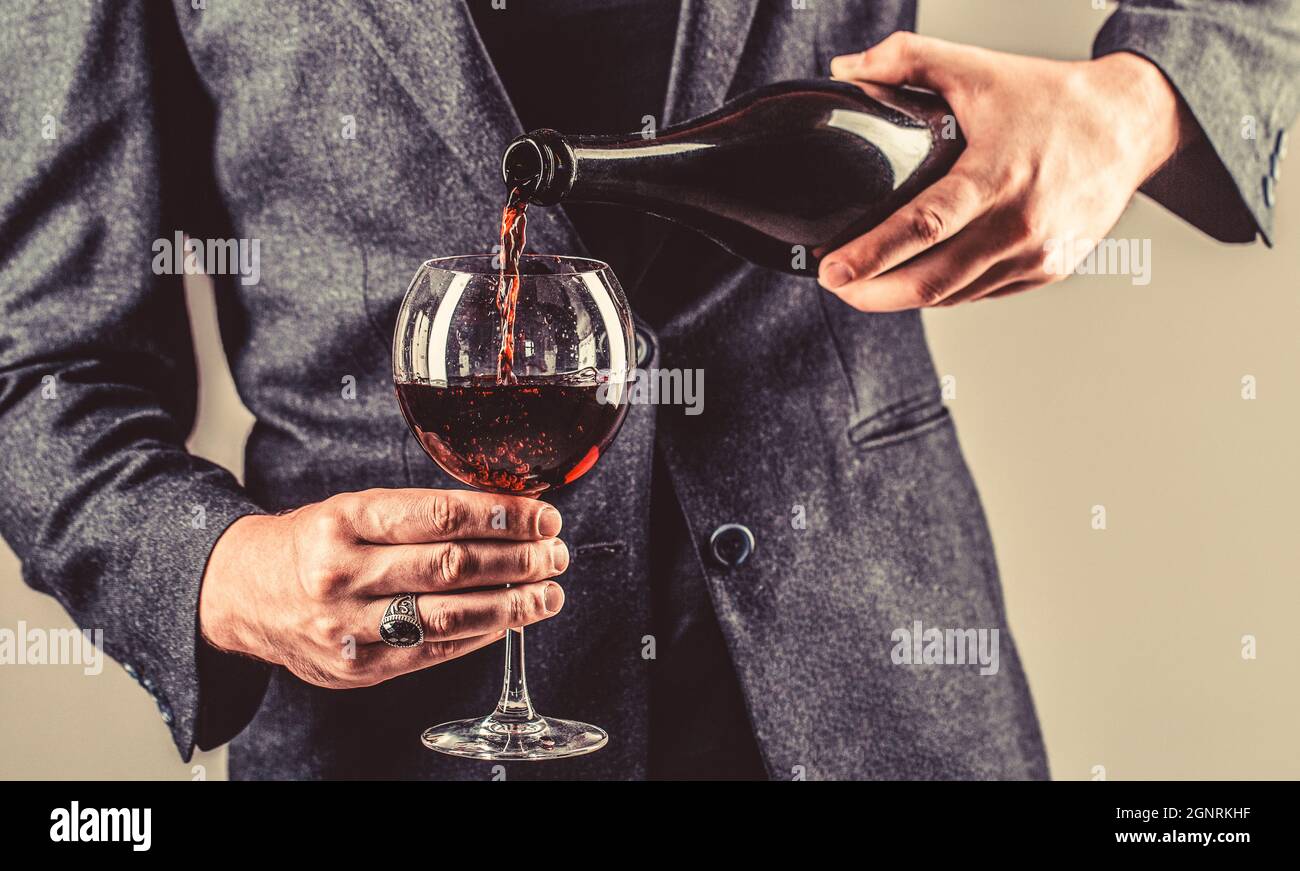 Red wine is poured from bottle to glass. Gourmet drink bottle, red wine