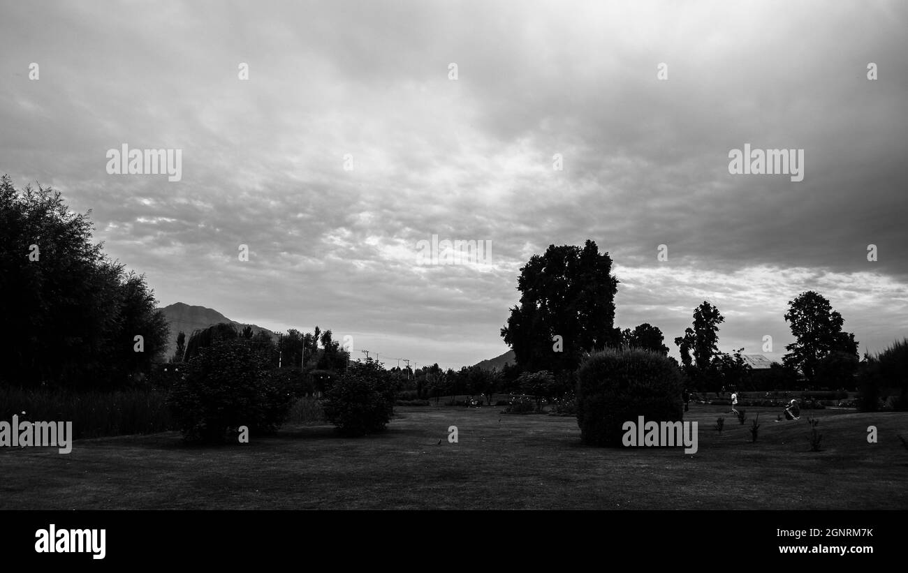 Blank and white image of landscape with mountains silhouetted in cloudy sky Stock Photo