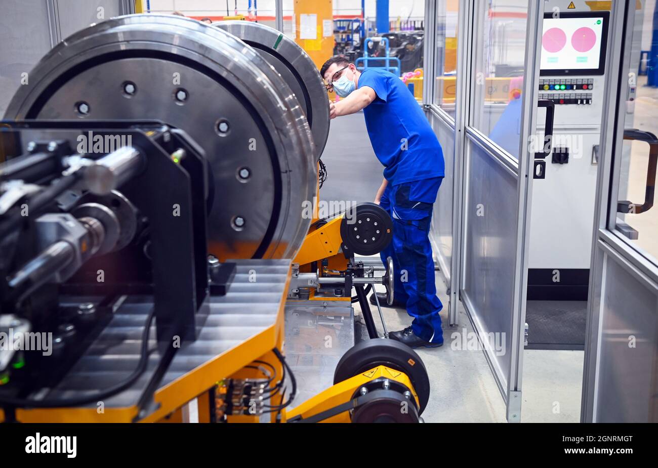 27 September 2021, Brandenburg, Schönwalde-Glien: Assembly fitter Martin Schweda works on the balancing machine on the bogie for a passenger train after the inauguration of the bogie inspection and production centre of Stadler Rail Service Deutschland GmbH. At the location in the Havelland district, bogies can be completely dismantled, cleaned, subjected to a checkup and reassembled on an area of around 4300 square metres. In addition to supplying other locations with spare parts from the logistics centre, Stadler is thus able to offer maintenance and possible reassembly of bogies as a service Stock Photo