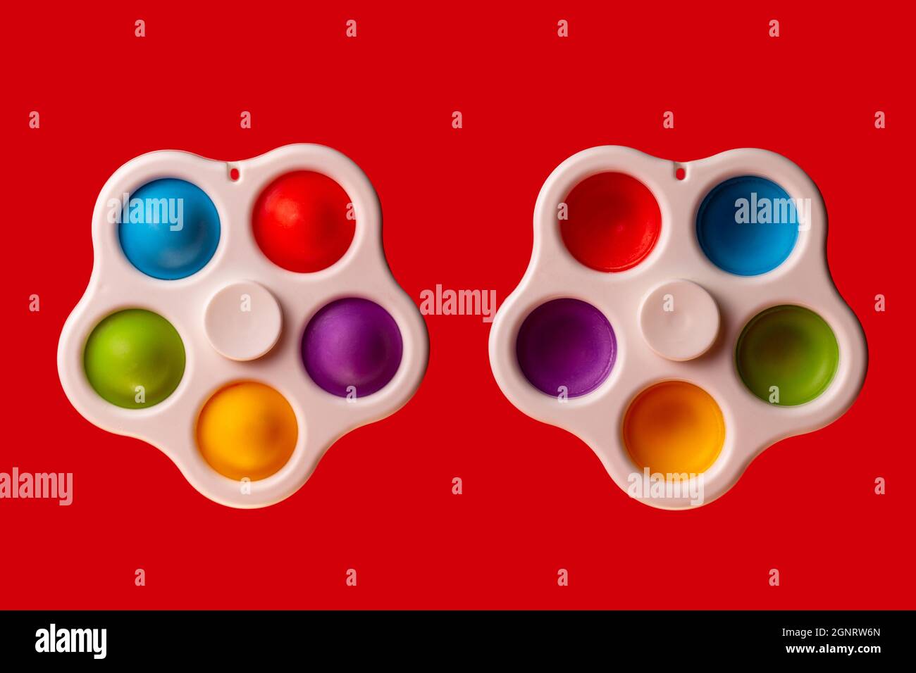 two simple dimple spinner on a red background. Pop-it Stock Photo - Alamy