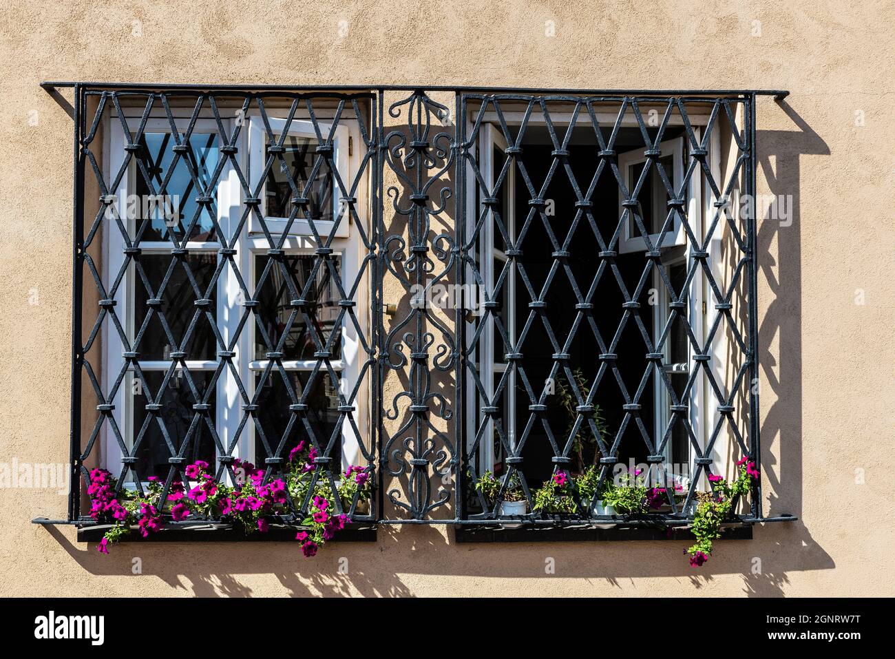 Two lattice windows with flower pots of an old classic building in the old town of Warsaw, Poland Stock Photo