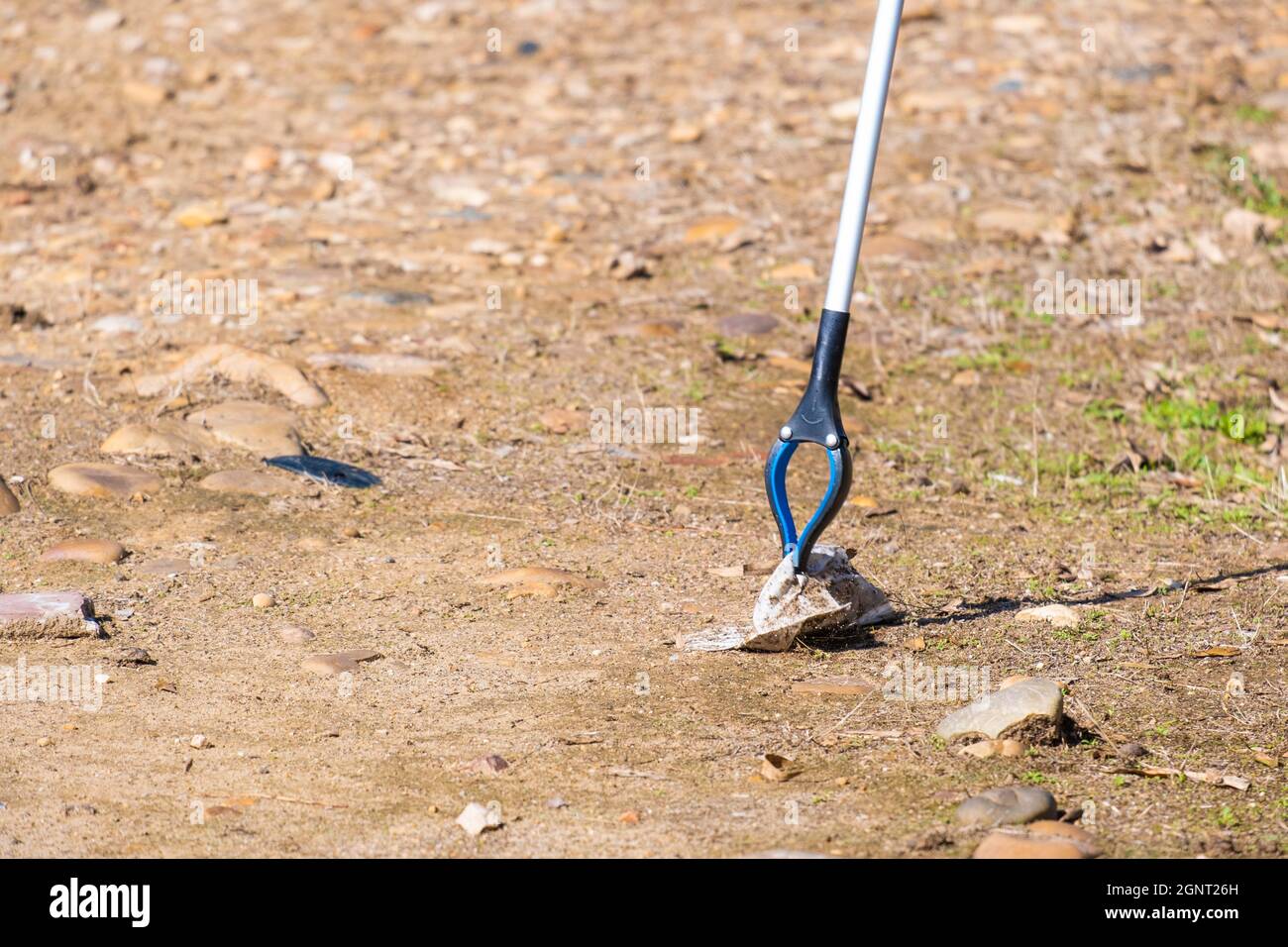 Detail shot of some pliers collecting garbage in the field. Environmental pollution concept, environmental activists Stock Photo