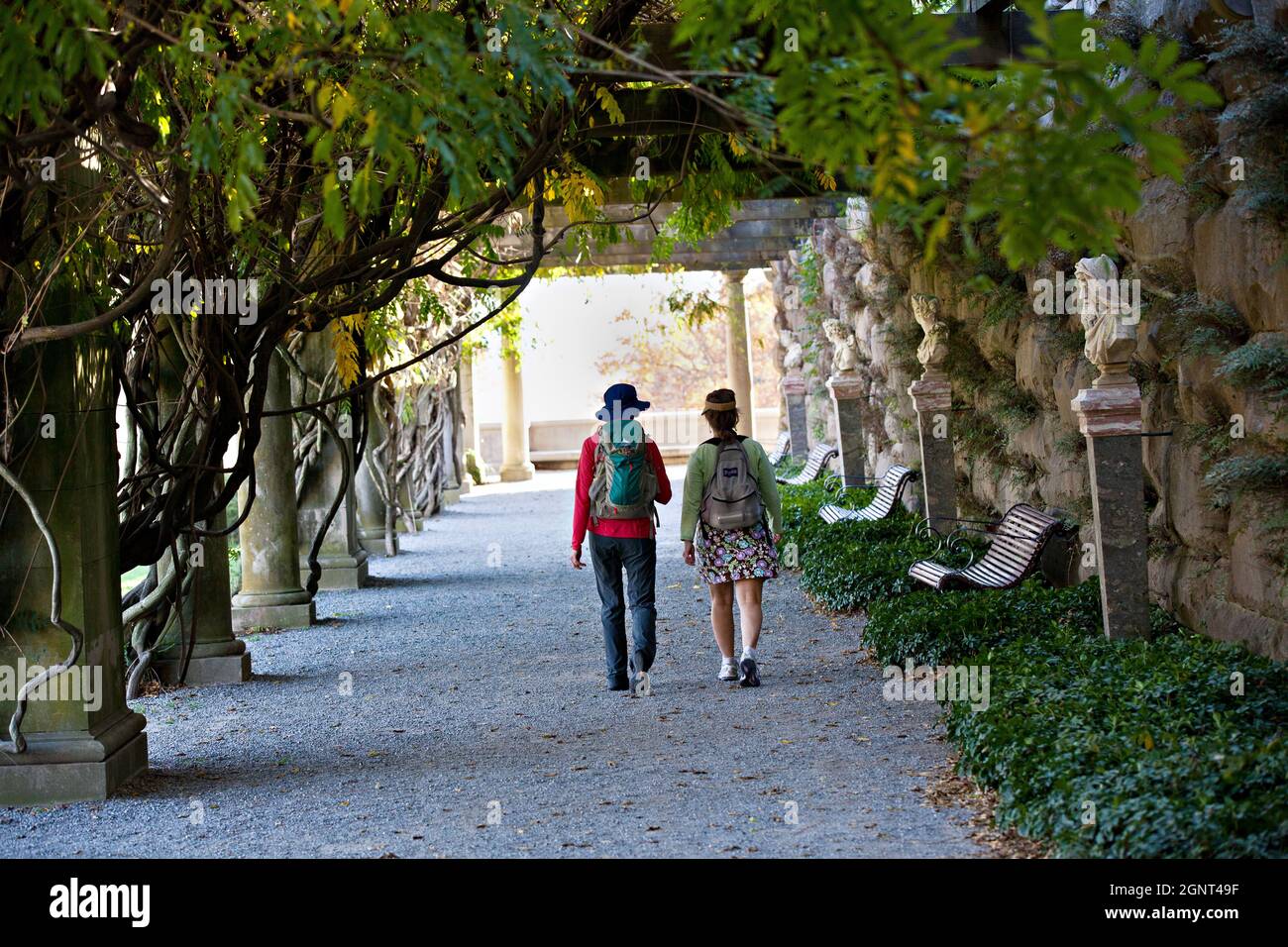 Two women walk through a vine tunnel in the walled gardens of the Biltmore Estate during autumn in Asheville, North Carolina. The house, privately owned by the Vanderbilt family, is the largest home in America with over 250 rooms. Stock Photo