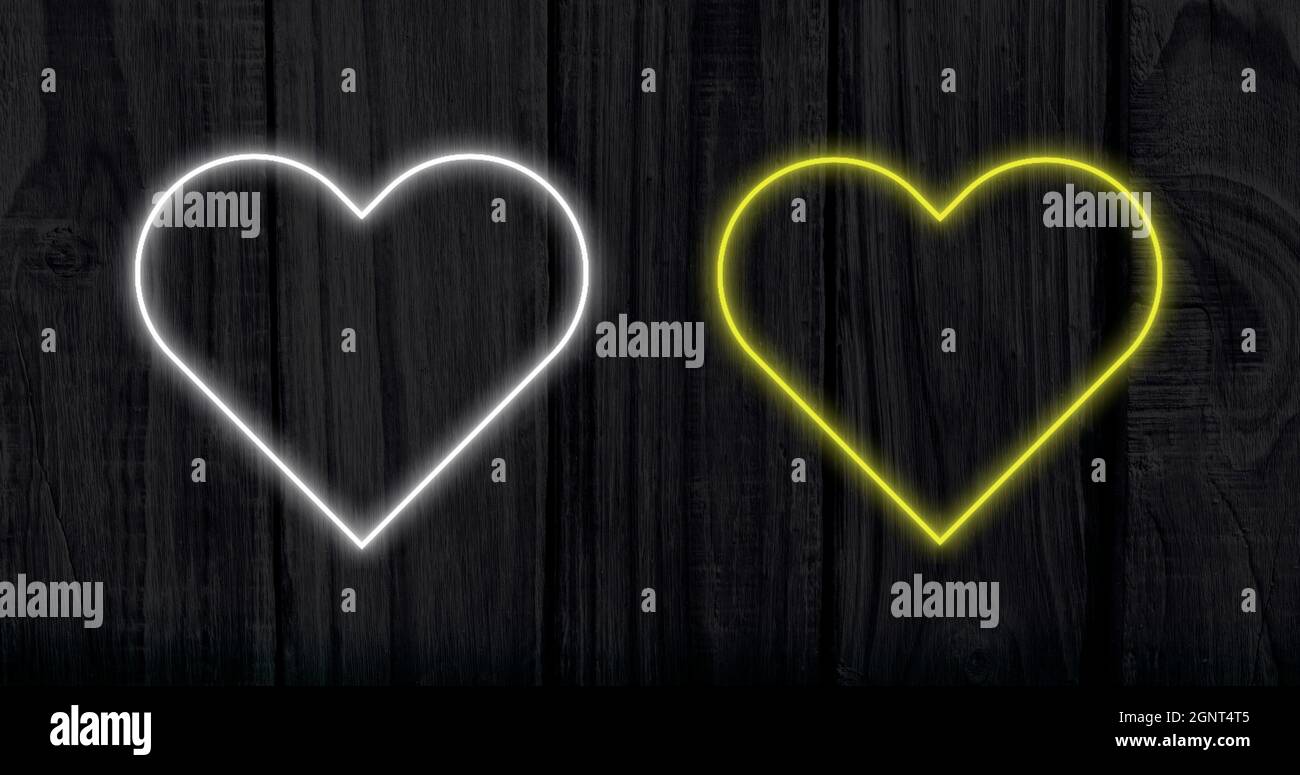 Image of white and yellow neon hearts flashing on dark streaked background Stock Photo