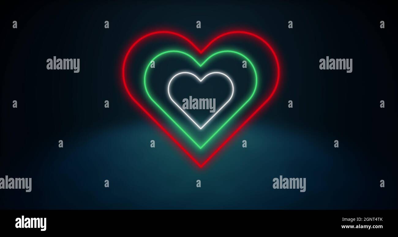 Image of red white and green concentric neon hearts flashing on darkly lit background Stock Photo