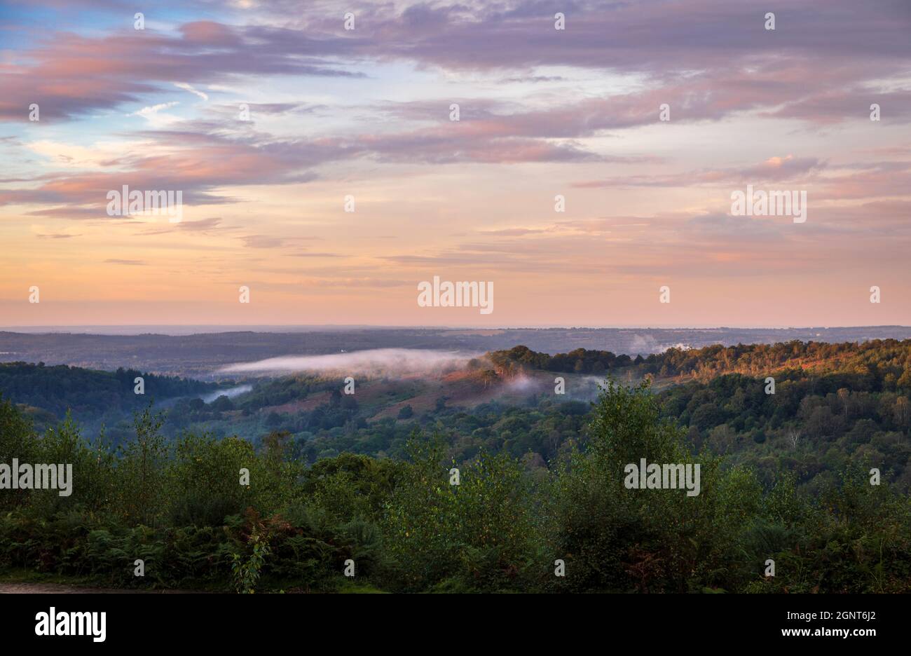 Low clouds and dramatic colours in the sky over the Devils Punch Bowl during sunset on the Surrey Hills near Hindhead south east England Stock Photo