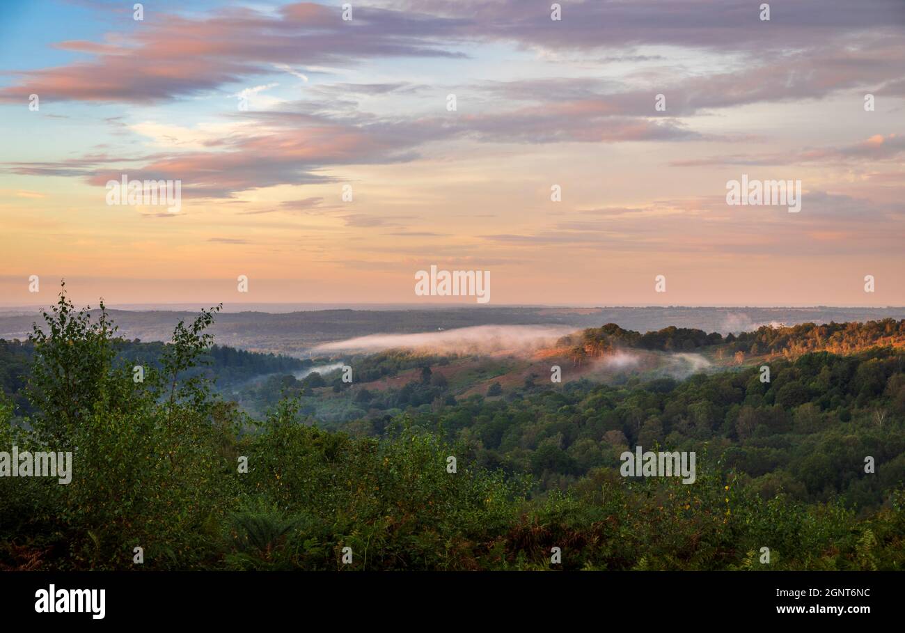 Low clouds and dramatic colours in the sky over the Devils Punch Bowl during sunset on the Surrey Hills near Hindhead south east England Stock Photo
