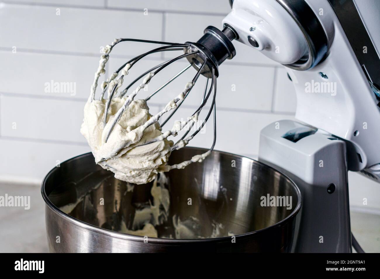 Mixing Whipped Cream in a Stand Mixer with a Whisk Attachment: Heavy  whipping cream mixed with a stand mixer wire whisk Stock Photo - Alamy