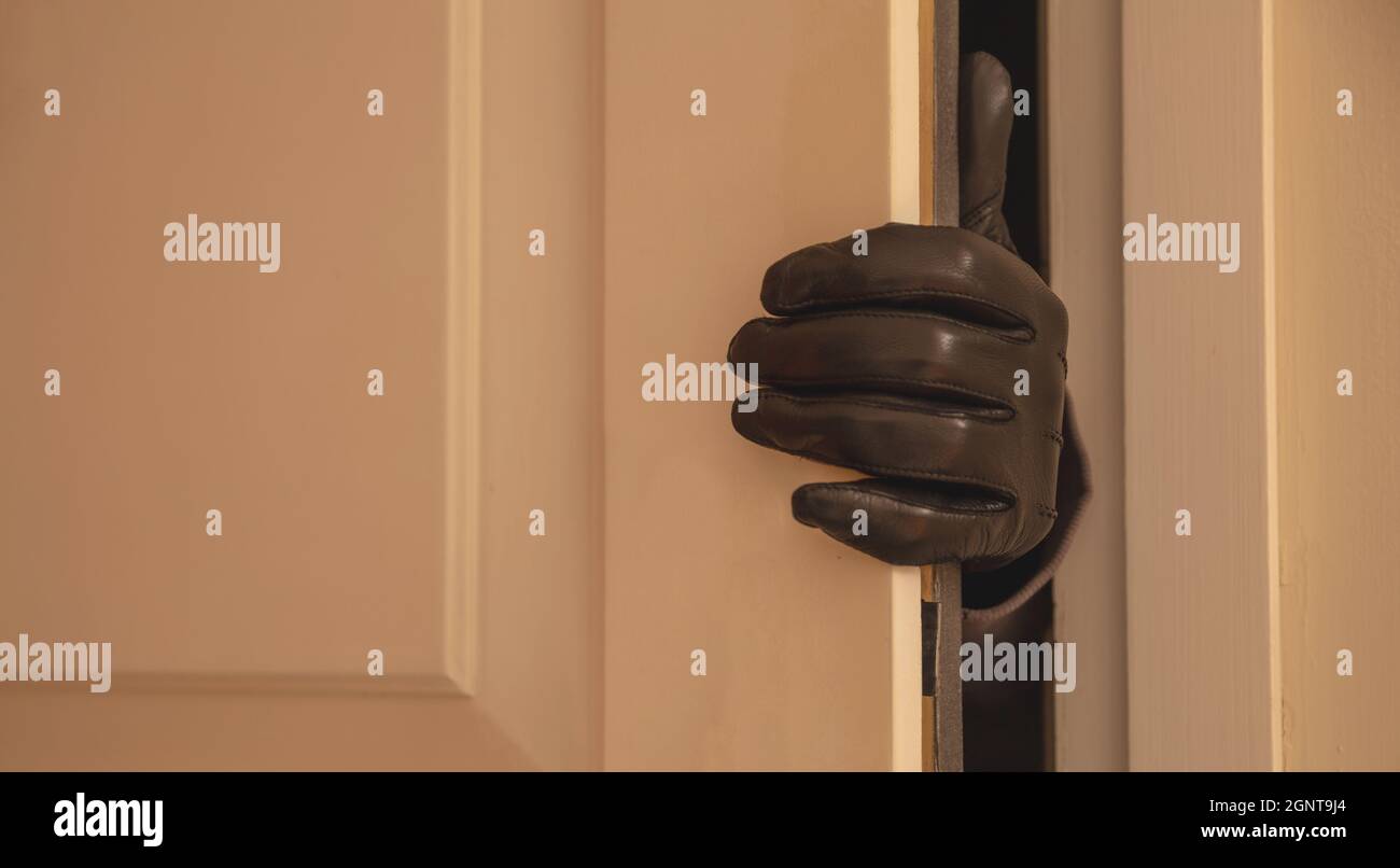 Housebreaking burglary concept. Gloved hand opening the entrance door burglar entering illegally the house Stock Photo Alamy