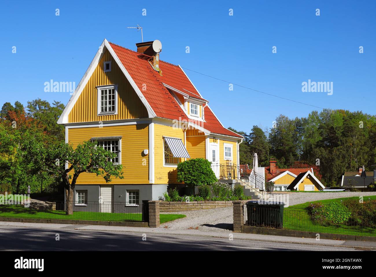 Yellow house single-family house with tiled gabled roof on two floors with basement built in the 1920s. Stock Photo