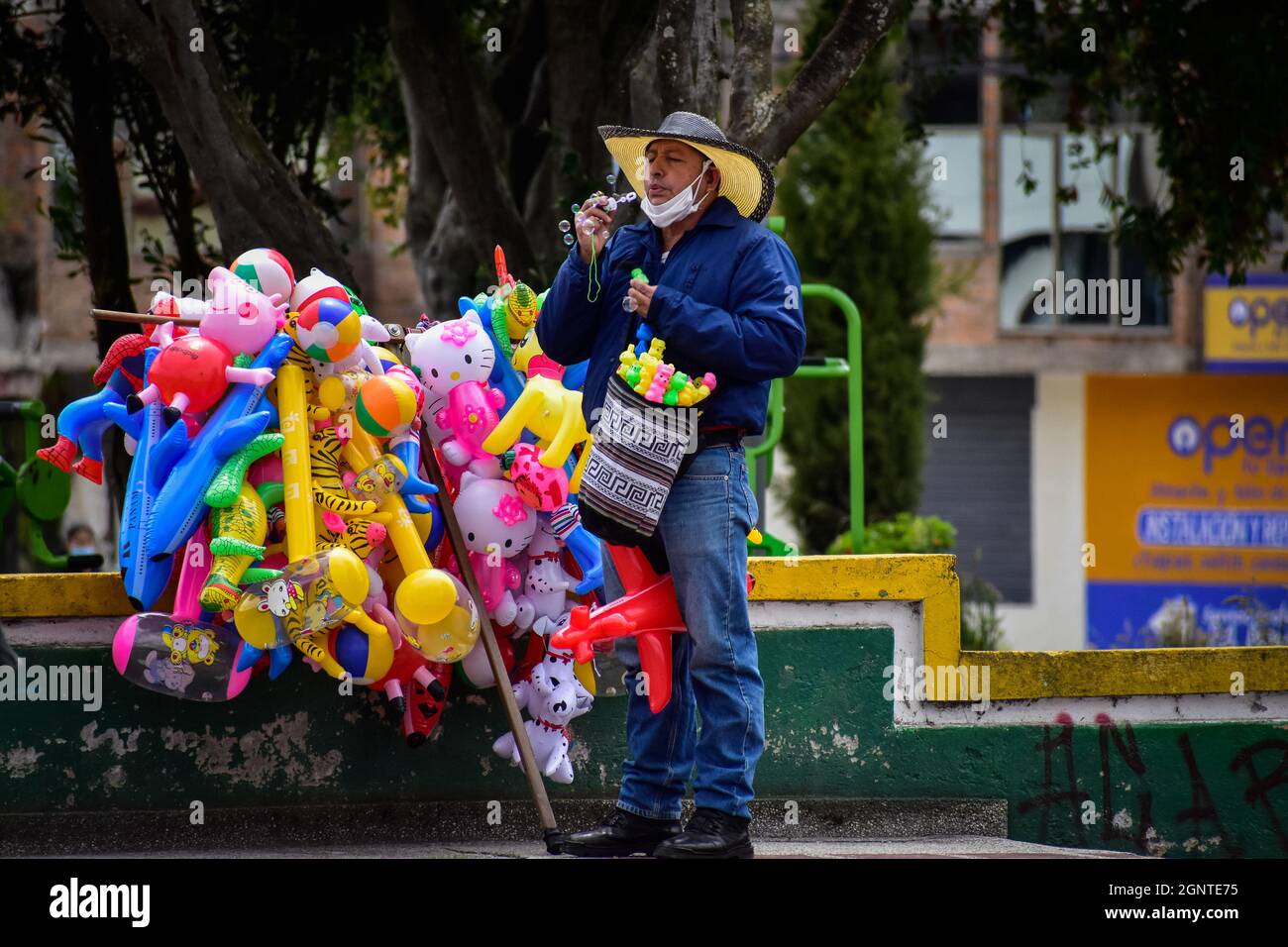 A street vendor blows bubbles from a toy in Cumbal - Nariño, Colombia on August 15, 2021. Stock Photo