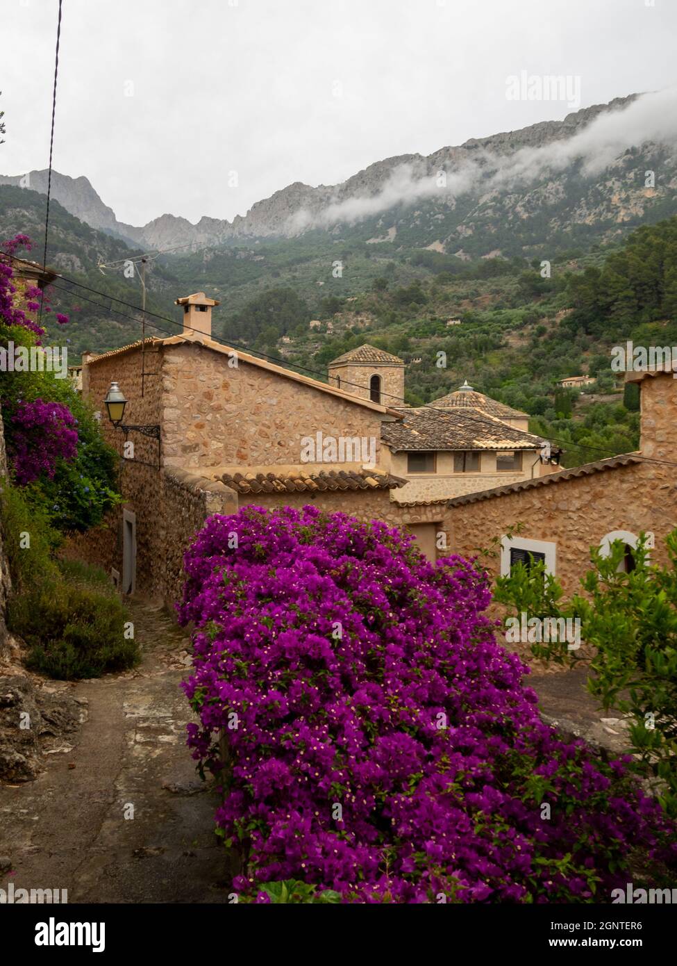 Cobbled streets and stone houses below Tramuntana mountains in Fornalutx Stock Photo