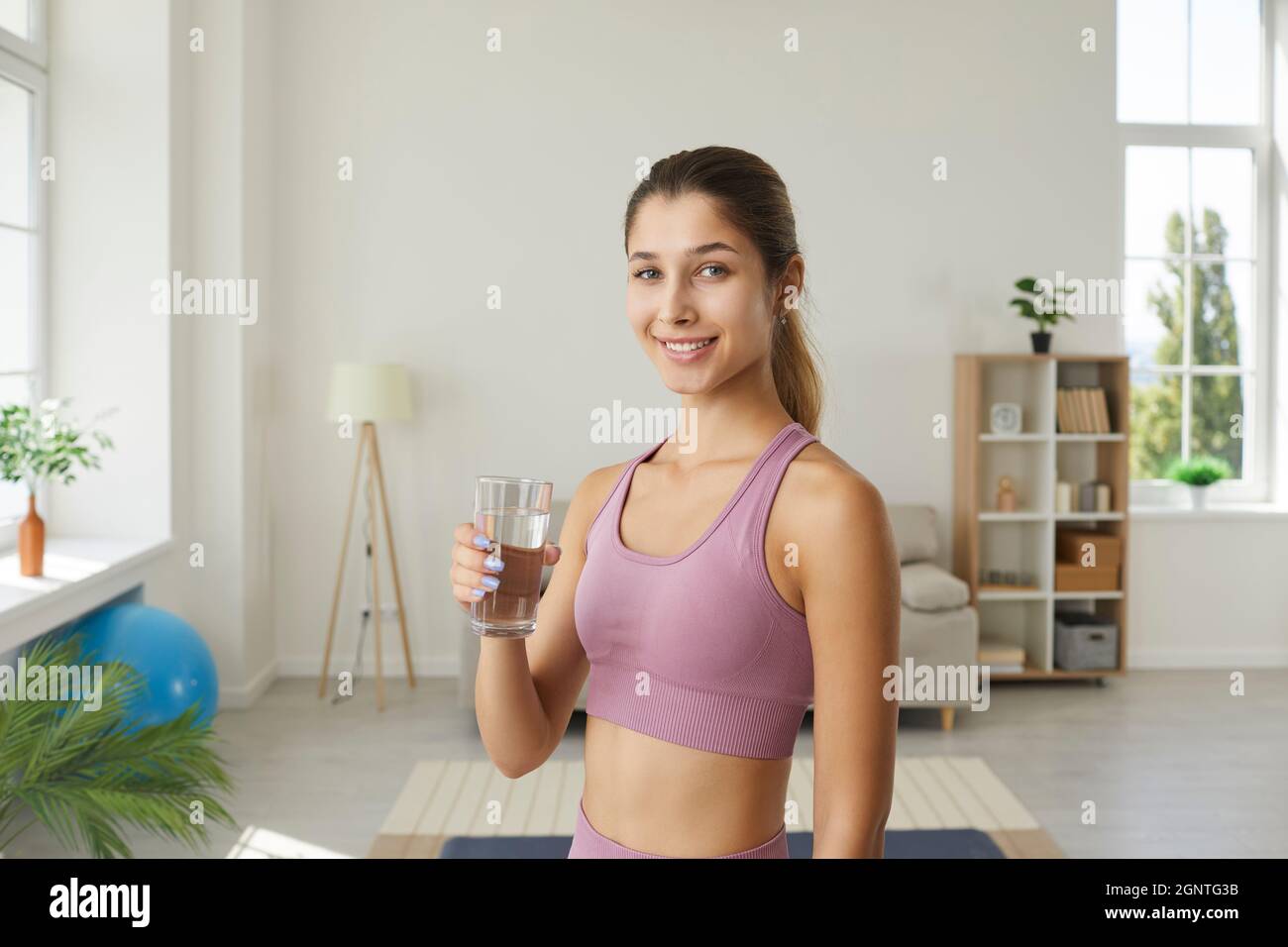Woman holding glass of water reminding to stay hydrated and lead healthy lifestyle Stock Photo
